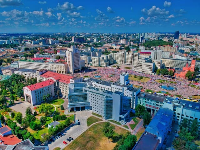 A large city square with people in front of tall buildings