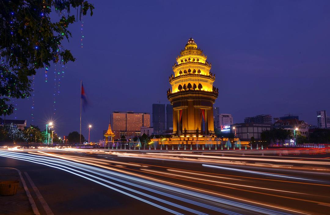 city in the evening, with a large cambodian stone statue