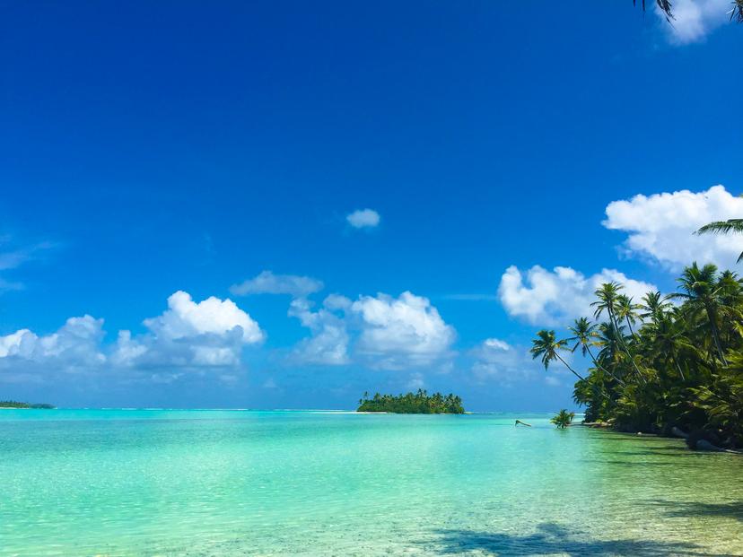 islands with palm trees, on blue water with blue skies