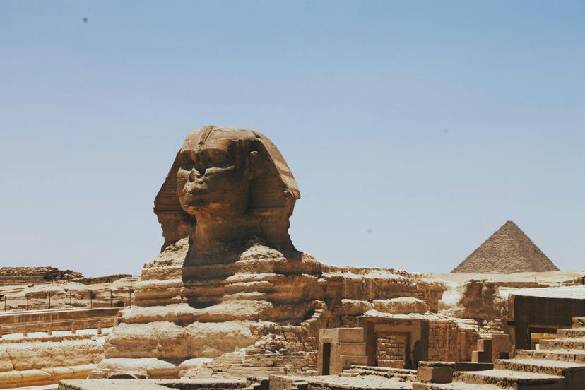 Great Sphynx of Giza, Egypt made of sandstone, in front of a pyramid