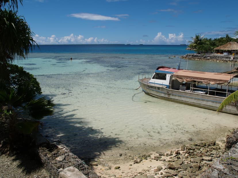 beach at the ocean, with a docked boat